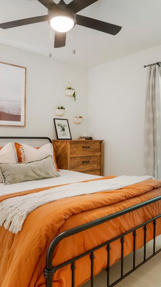 a bedroom with a bed, dresser and fan at The  Marley