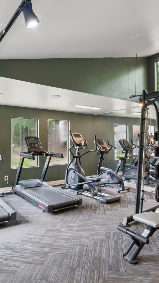 a gym room with tread machines and exercise equipment at The Marley
